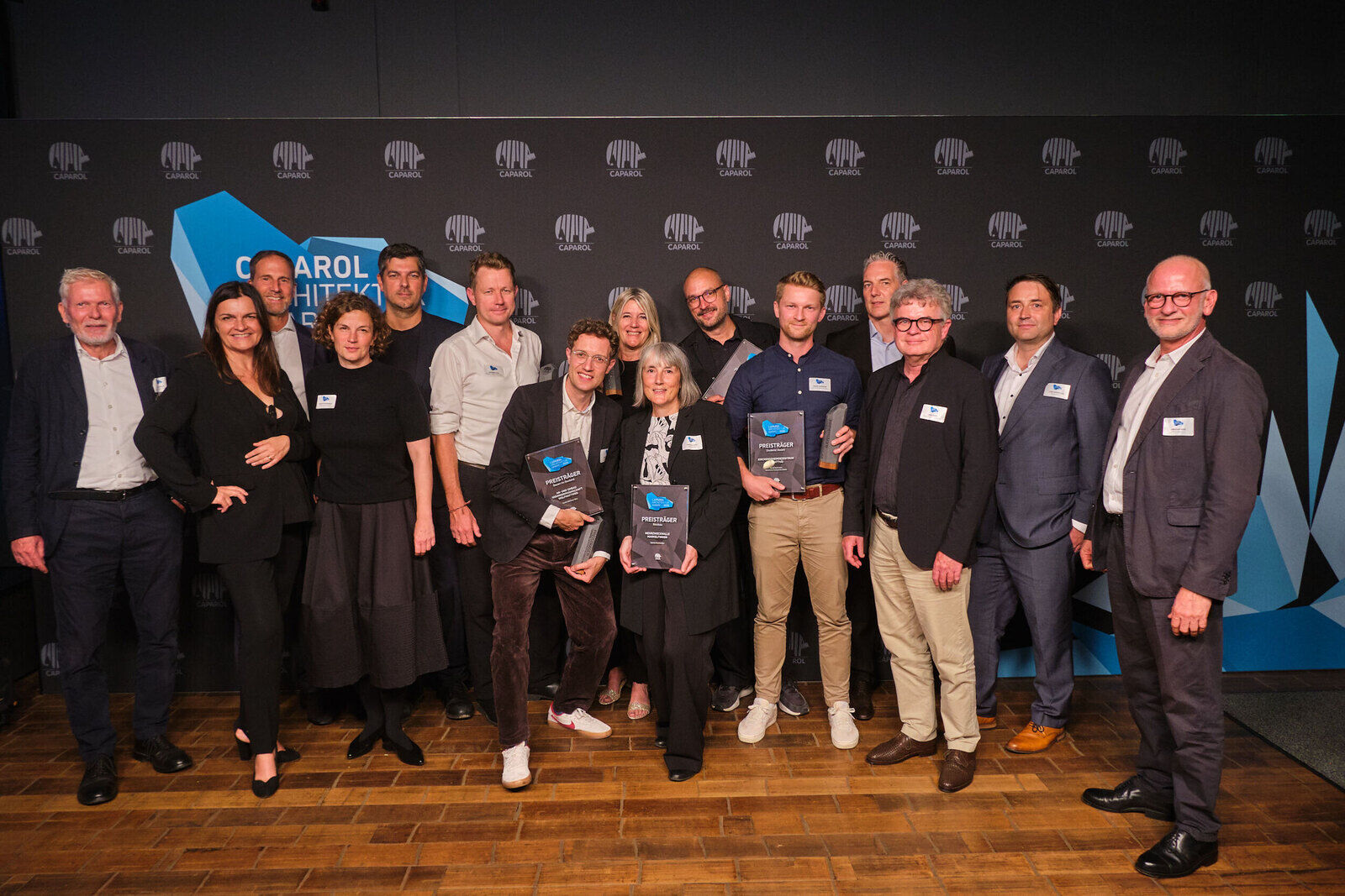 Gruppenfoto bei der Preisverleihung des Caparol Architektur Award 2026 in Hamburg vor einer Wand mit Caparol-Logos